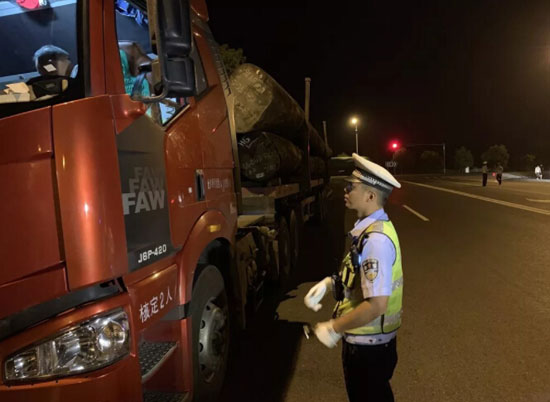 圖為交警正在對過往車輛進行過磅檢查